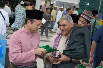 Menteri Negara Kanan (Pertahanan merangkap Tenaga Manusia), Encik Zaqy Mohamad (kanan) melaksanakan solat sunat Aidilfitri di Masjid An-Nur untuk bertemu dan bermesra bersama masyarakat Islam di Marsiling. 