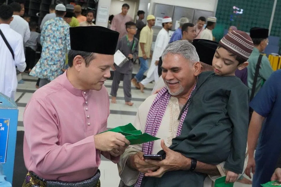 Menteri Negara Kanan (Pertahanan merangkap Tenaga Manusia), Encik Zaqy Mohamad (kanan) melaksanakan solat sunat Aidilfitri di Masjid An-Nur untuk bertemu dan bermesra bersama masyarakat Islam di Marsiling. 