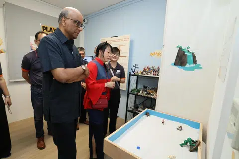 Semasa lawatan ke Pusat Perkhidmatan Keluarga (FSC) Reach di Sin Ming Avenue pada 30 April, Presiden Tharman Shanmugaratnam (kiri) bersama isterinya, Puan Jane Ittogi (dua dari kiri) telah diperkenalkan kepada komponen terapi bermain inisiatif Projek GEMinate, termasuk peluang untuk mencuba alat terapi berkenaan.