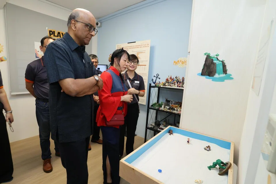 Semasa lawatan ke Pusat Perkhidmatan Keluarga (FSC) Reach di Sin Ming Avenue pada 30 April, Presiden Tharman Shanmugaratnam (kiri) bersama isterinya, Puan Jane Ittogi (dua dari kiri) telah diperkenalkan kepada komponen terapi bermain inisiatif Projek GEMinate, termasuk peluang untuk mencuba alat terapi berkenaan.