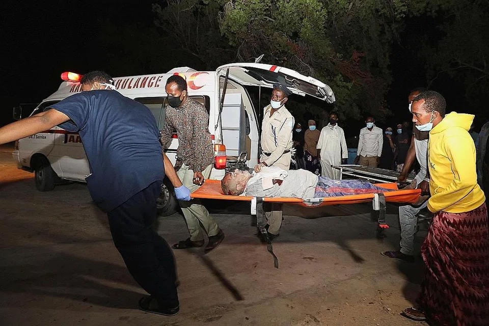 RAKYAT JADI MANGSA: Sekumpulan orang membantu mengusung seorang mangsa yang cedera ke Hospital Madina Hospital selepas satu letupan berlaku di restoran Luul Yemeni berdekatan pelabuhan Mogadishu, Somalia, pada 5 Mac lalu. - Foto REUTERS