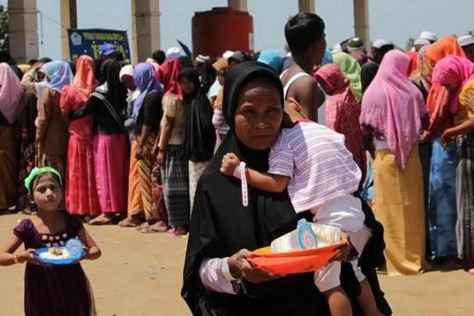 HARAPKAN BELAS IHSAN WARGA DUNIA: Seorang wanita Rohingya dilihat membawa pinggan di kem pendatang Rohingya dan Bangladesh di Kuala Cangkoi, Aceh, awal bulan ini. - Foto AFP