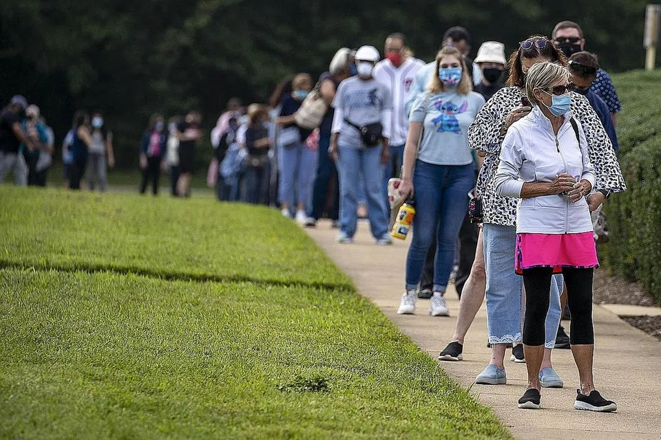 TUNGGU GILIRAN MENGUNDI: Orang ramai beratur sambil mematuhi arahan jarak selamat dek Covid-19, untuk mengundi awal di Pusat Pemerintah Fairfax baru-baru ini di Fairfax, Virginia. - Foto AFP