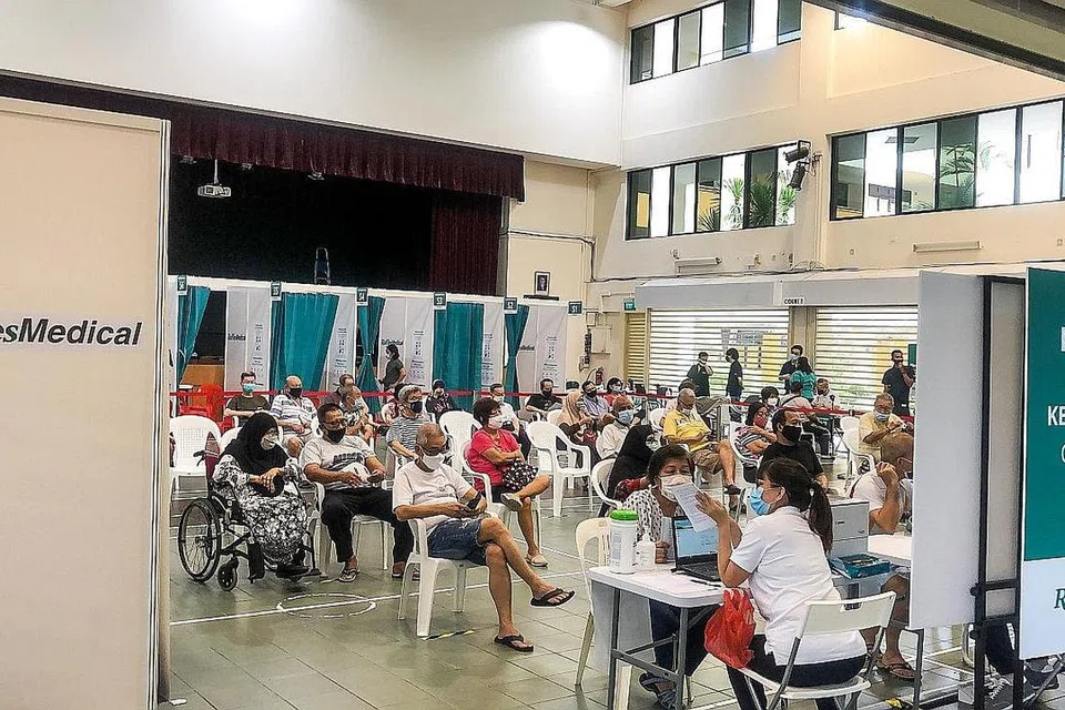 TUNGGU GILIRAN DAPATKAN VAKSIN: Orang ramai menanti giliran mendapatkan vaksin Moderna di Kelab Masyarakat Hong Kah North semalam - antara empat kelab masyarakat yang akan menjalankan vaksinasi bagi vaksin Moderna. - Foto LIANHE ZAOBAO