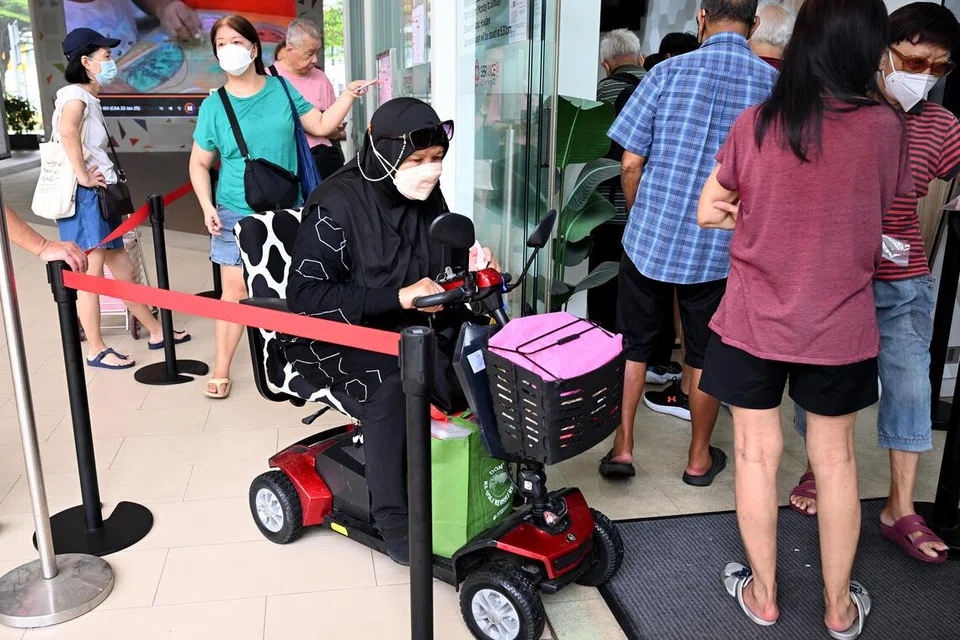 Cik Rukiah Ahmat, 73 tahun, mengambil pelitup N95 di Kelab Masyarakat Keat Hong pada 15 Oktober.