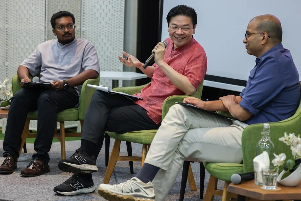 Editor Berita ‘Tamil Murasu’, Encik Irshath Mohamed (kiri), bersama Perdana Menteri, Encik Lawrence Wong, dan Menteri Negara Kanan (Penerangan dan Pembangunan Digital merangkap Kesihatan), Dr Janil Puthucheary, bercakap dengan lebih 130 belia dalam kalangan anggota masyarakat India. 
