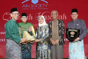 BAPA CONTOH: Encik Abdul Manaf Rahmat (kiri sekali) terima Anugerah Qudwah Hasanah (Ayah Contoh Terbaik) 2019 daripada Presiden Halimah (tengah). Ketua Pegawai Eksekutif Persatuan Ain, Encik Haji Md Yusof Ismail (dua dari kiri), suami Puan Halimah, Encik Md Abdullah Alhabshee (empat dari kiri) dan Presiden Persatuan Ain, Encik Abdul Malek Osman (kanan sekali) turut hadir dalam majlis penyampaian Anugerah di Hotel Orchard. - Foto MCI