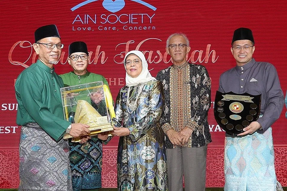 BAPA CONTOH: Encik Abdul Manaf Rahmat (kiri sekali) terima Anugerah Qudwah Hasanah (Ayah Contoh Terbaik) 2019 daripada Presiden Halimah (tengah). Ketua Pegawai Eksekutif Persatuan Ain, Encik Haji Md Yusof Ismail (dua dari kiri), suami Puan Halimah, Encik Md Abdullah Alhabshee (empat dari kiri) dan Presiden Persatuan Ain, Encik Abdul Malek Osman (kanan sekali) turut hadir dalam majlis penyampaian Anugerah di Hotel Orchard. - Foto MCI