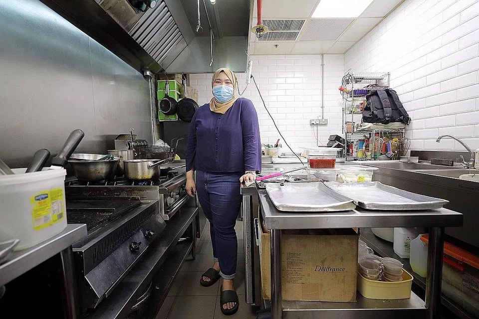 MODEL NIAGA BARU: Dari kemudahan dapur pusat Tampines Food Co, di JTC Space, Tampines North Drive 4, yang dikongsi sekitar 20 syarikat makanan dan minuman (F&B) lain, Cik Aina menumpukan perhatian kepada tempahan makanan dalam talian yang menawarkan penghantaran bagi tiga jenama makanannya - The Flameshack, Daun by The Flameshack dan Pastahaus. - Foto BH oleh GAVIN FOO