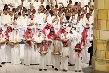 Para sukarelawan bersiap sedia mengagihkan manisan ketika umat Islam berhimpun menunaikan solat sunat Aidilfitri di Masjidil Haram pada awal pagi 30 Mac.