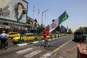 Seorang pekerja mengangkat tiang yang memaparkan bendera Iran di Dataran Enghelab, Tehran pada 3 Jun 2026. Penasihat ketenteraan kepada pemimpin tertinggi Iran pada 3 Jun memberi amaran bahawa lebih banyak serangan peluru berpandu dan dron akan dilancarkan sekiranya Amerika Syarikat memperbaharui serangannya terhadap Iran.