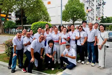 Peguam dan calon simpanan bagi GE2025, Encik Ahmad Firdaus Daud (lima dari kiri), bersama Anggota Parlimen GRC Marine Parade-Braddell Heights di satu acara pengagihan baucar pada 23 Ogos.