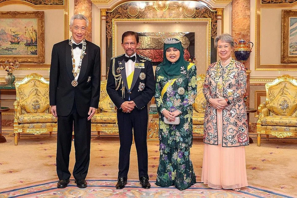  HUBUNGAN ISTIMEWA DUA HALA: (Dari kiri) Encik Lee, Sultan Hassanal Bolkiah, Raja Isteri Pengiran Anak Hajah Saleha dan Cik Ho Ching, yang turut menerima anugerah Darjah Paduka Seri Laila Jasa - Kelas Pertama, bergambar selepas majlis anugerah yang diadakan di di Istana Nurul Iman malam kelmarin. - Foto MCI