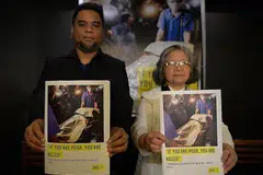 BENTANGKAN LAPORAN: Encik Wilnor Papa dan Sister Maria Cordero, daripada Amnesty International bersama salinan laporan mereka yang menunjukkan gambar mayat pesalah dadah yang ditembak mati pihak polis. - Foto AFP