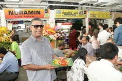 SAMBUNG NIAGA KELUARGA: Encik Abdul Malik, yang sebelum ini membantu datuknya menjual makanan di tepi jalan di Raffles Place, menyambung perniagaan keluarganya di Tempat Letak Kereta Golden Shoe dan kini di pusat makanan sementara Cross Street. - Foto JOHARI RAHMAT