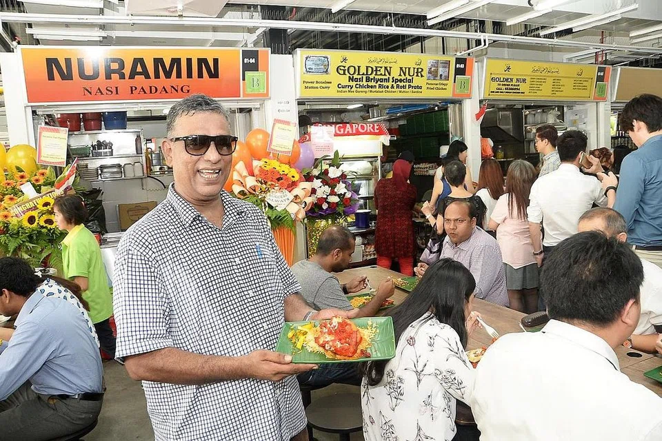 SAMBUNG NIAGA KELUARGA: Encik Abdul Malik, yang sebelum ini membantu datuknya menjual makanan di tepi jalan di Raffles Place, menyambung perniagaan keluarganya di Tempat Letak Kereta Golden Shoe dan kini di pusat makanan sementara Cross Street. - Foto JOHARI RAHMAT