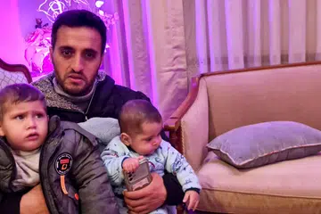 Encik Khamis Abu Syaaban, 36 tahun, bersama-sama dua anaknya, Zakaria (kiri), satu setengah tahun, dan Ahmad, lima bulan serta isteri, Cik Suoad (tiada dalam gambar), kini tinggal di kediaman sementara di Kahirah, Mesir, sejak perang meletus.