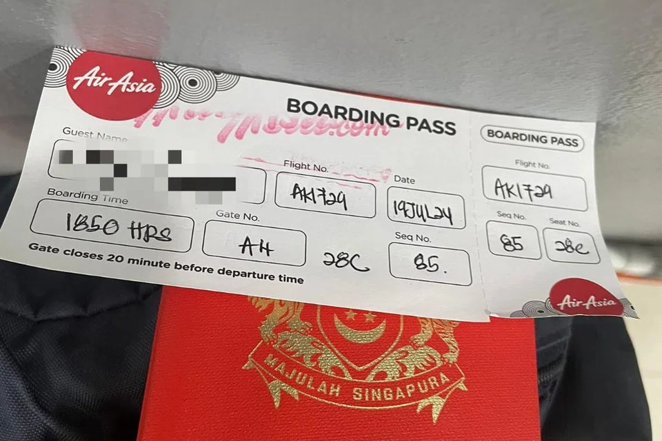 Air Asia memberi penumpang pas masuk pesawat bertulis ketika mengalami isu kegenjotan IT.  