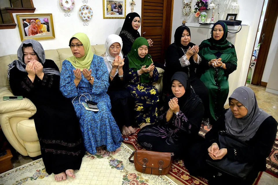 MAJLIS TAHLIL KELUARGA: Keluarga Allahyarham Othman Wok mengadakan tahlil di rumah Allahyarham di Kew Avenue. Gambar menunjukkan (duduk di sofa, dari kiri) Cik Diana Othman, anak isteri kedua Encik Othman, Cik Lina Abdullah; Cik Lily Othman, anak bongsu isteri pertama Allahyarhamha Cik Dah Mohd Noor; balu Encik Othman, Cik Lina Abdullah; isteri presiden pertama Singapura Encik Yusof Ishak, Puan Noor Aishah Md Salim; dan Cik Safiah Othman, anak sulung isteri pertama Allahyarham (duduk di kerusi, dua dari kanan). - Foto M.O. SALLEH