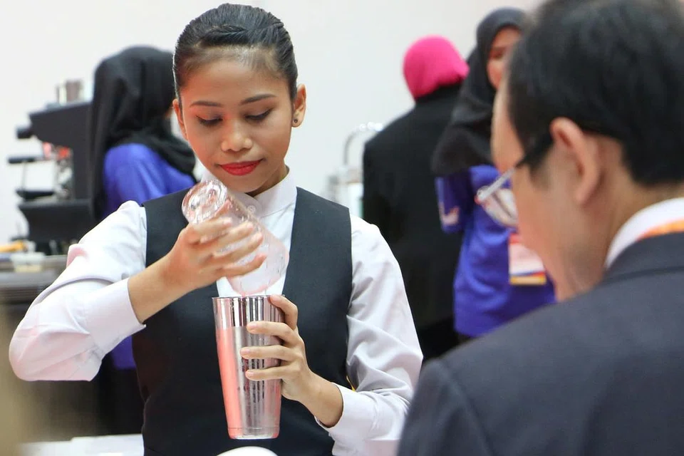 PENUH FOKUS: Cik Zahirah beraksi di Pertandingan Kemahiran Asean (ASC) 2016, menyediakan minuman untuk pelanggan, dalam kategori khidmat restoran. - Foto ITE