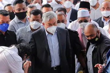 ADA KES: Datuk Dr Ahmad Zahid (tengah) tiba di Kompleks Mahkamah Tinggi Kuala Lumpur semalam diiringi penyokongnya. Hakim berkata mahkamah mendapati pendakwa telah membuktikan semua ramuan pertuduhan untuk dia membela diri bagi 12 pertuduhan pecah amanah, lapan pertuduhan rasuah, dan 27 pertuduhan penggubahan wang haram. - Foto REUTERS