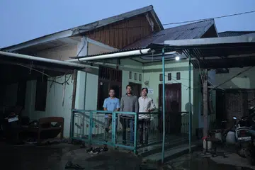 (Dari kiri) Encik Feriansyah bersama dua adiknya, Encik Muhammad Faisal dan Encik Ardiansyah, membesar di rumah ini yang menyatukan anggota keluarga mereka sebelum tsunami melanda. Rumah itu dibina semula beberapa tahun selepas musnah akibat tsunami.