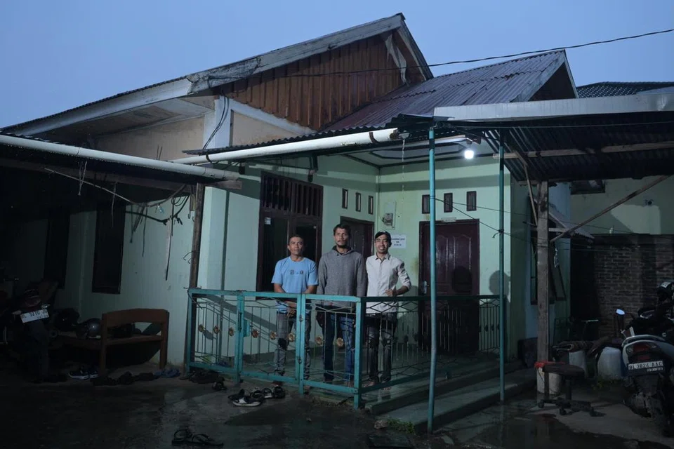 (Dari kiri) Encik Feriansyah bersama dua adiknya, Encik Muhammad Faisal dan Encik Ardiansyah, membesar di rumah ini yang menyatukan anggota keluarga mereka sebelum tsunami melanda. Rumah itu dibina semula beberapa tahun selepas musnah akibat tsunami.