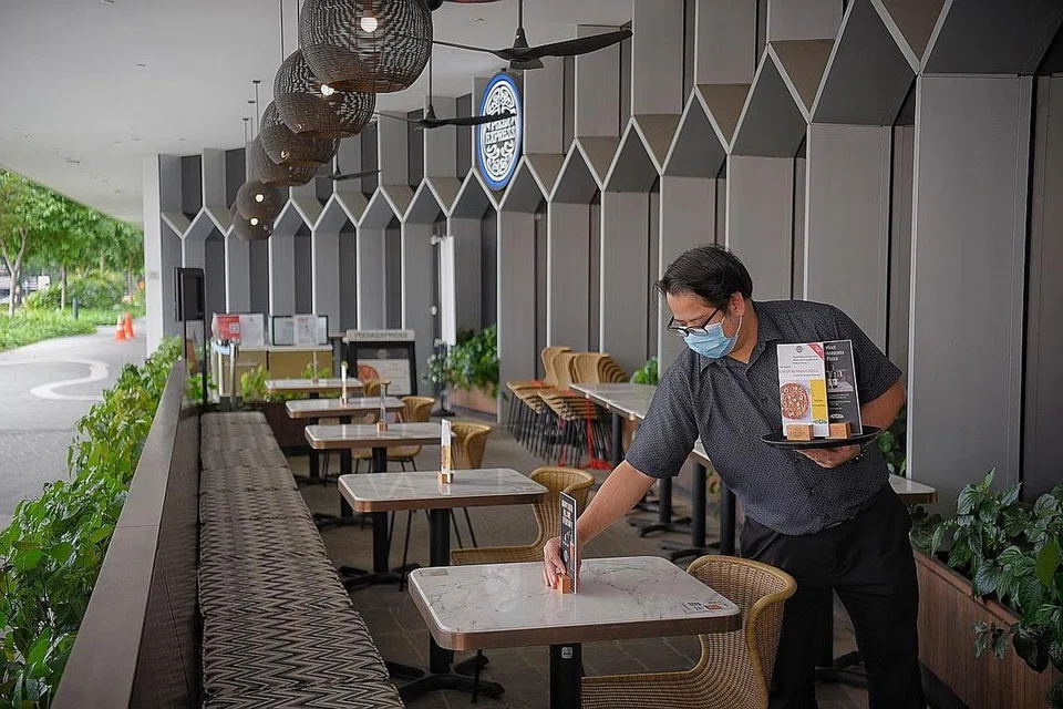 BUAT PERSIAPAN: Kakitangan sebuah restoran ini menyiapkan meja untuk dua orang apabila orang ramai dibenarkan semula menjamu selera di luar mulai esok. - Foto BM oleh MARK CHEONG