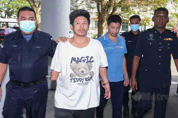 Lelaki yang kudung tangan kanan, Mah Cheow Chuen (dua dari kiri), dan rakannya Muhammad Zaim Goh Abdullah (tiga dari kiri) diiringi polis atas kesalahan lakukan rompakan.