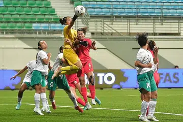 CUBA REBUT BOLA: Pemain Singapura, Nur Farhanah (jersi merah), melompat tinggi untuk cuba menanduk bola semasa menentang Indonesia kelmarin. - Foto BH oleh DESMOND WEE