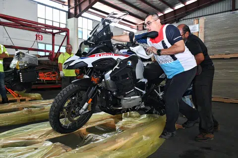 (dari kanan) Encik Mohamed Yusof Mohamed dan Encik Mohd Anis Mohd Kassim memuatkan motosikal ke atas kayu palet supaya dapat dimuatkan ke dalam kontena pada 6 Disember 2024 untuk dihantar ke Karachi, Pakistan.
