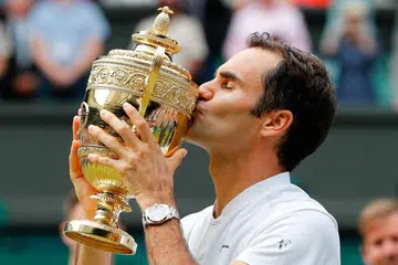 JUARA: Roger Federer dari Switzerland mencium tropi kemenangan setelah menewaskan pemain Croatia Marin Cilic dalam final kejohanan Wimbledon kelmarin. - Foto AFP