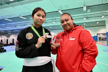 RAIH PINGAT PERAK: Quraifah Aqiffah Muhammad Suria (kiri), berjaya meraih pingat perak di peringkat akhir kelas D Wanita (60-65 kilogram) Kejohanan Pencak Silat Asia Ke-10 2026 di Vietnam, yang berlangsung dari 17 hingga 22 Julai.