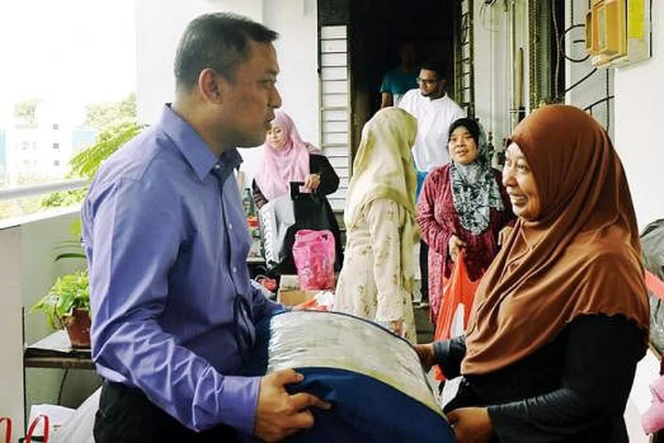HULUR BANTUAN: Haji Rahim bersama kakitangan Masjid An-Nur menziarahi rumah Cik Azlena di Marsiling Drive semalam untuk memberikan bantuan termasuk wang derma yang dikutip kakitangan masjid serta orang ramai. - Foto KHALID BABA
