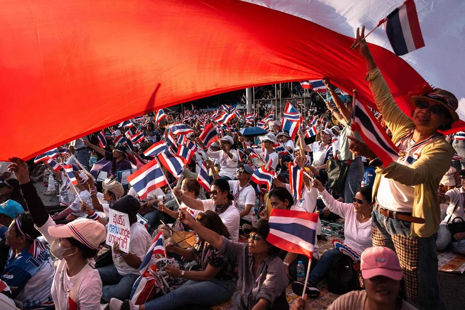 Penunjuk perasaan antikerajaan mengibarkan bendera kebangsaan Thailand semasa perhimpunan bagi mengecam perang dengan Kemboja dan menuntut peletakan jawatan Perdana Menteri Thailand yang digantung tugas, Cik Paetongtarn Shinawatra, di Tugu Peringatan Kemenangan  di Bangkok pada 2 Ogos. 