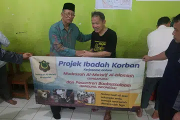 Cikgu Mohd Ma’mum Suheimi (kiri) bersama kiai Encik Muhammad Hasan Mukarrom, ketika mengagihkan daging korban di Indonesia. Foto dirakam beberapa tahun lalu. 