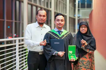 Encik Nasiruddin Mohd Rafiq (tengah), menamatkan pengajian di Politeknik Republic (RP) sebagai pelajar terbaik kohortnya bagi Diploma Pengurusan dan Penggalakan Kesihatan. Beliau bergambar bersama ibu bapanya, Encik Mohd Rafiq Abdul Rahim, dan Cik Ratina Maideen Sahib, yang menjadi tonggak sokongan kuat sepanjang perjalanannya.