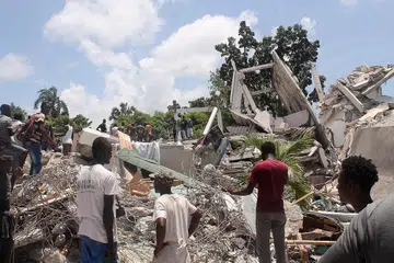 CARI MANGSA: Orang ramai menghulurkan bantuan mencari mangsa yang masih selamat di tapak Hotel Manguier yang runtuh menyusuli gempa kuat yang melanda Haiti. - Foto AFP