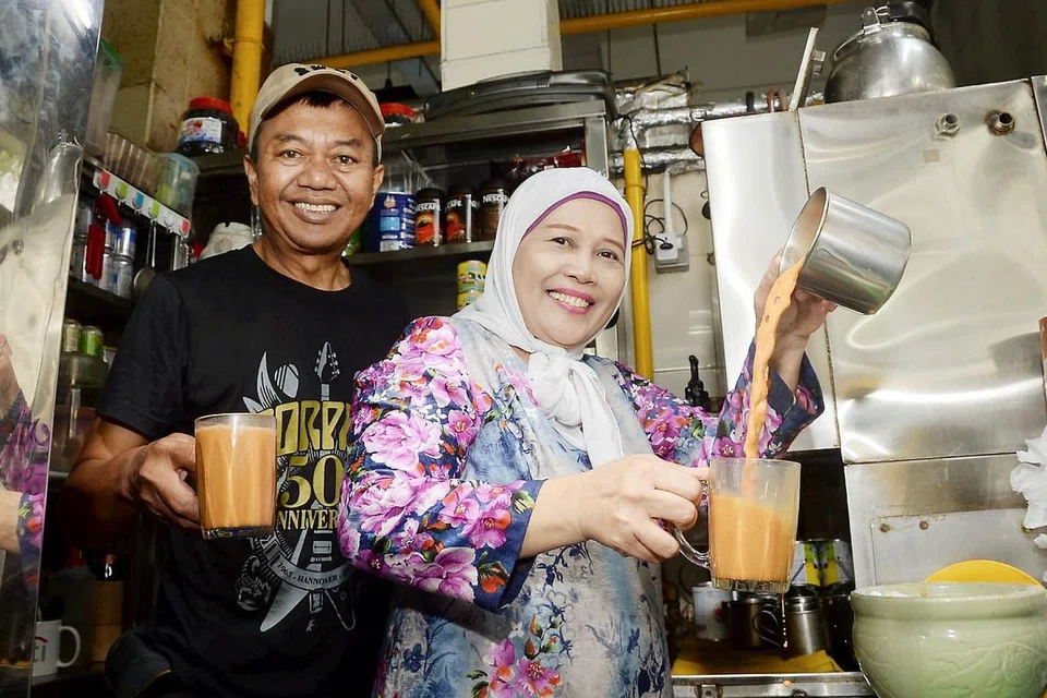 LARIS: Cik Alijah Osman dan suami, Encik Jaafar Sudin, sudah berjualan di gerai Anees Drinks Stall di Pusat Makan Amoy Street sejak lima tahun lalu. Teh tarik mereka merupakan antara kegemaran pelanggan di situ yang kebanyakannya merupakan pelanggan berulang. - Foto JOHARI RAHMAT
