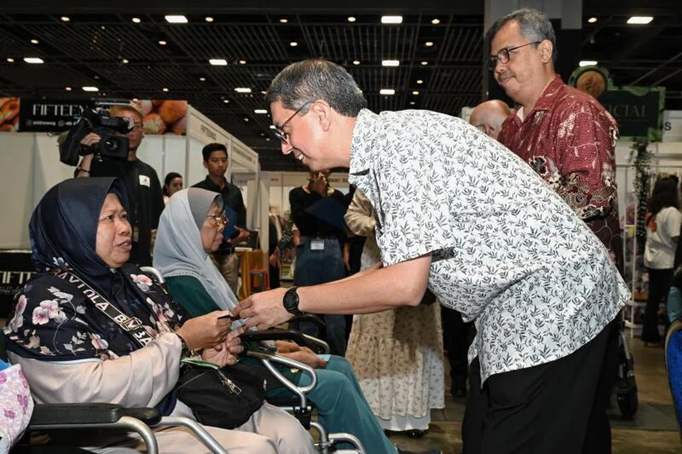 Cik Suriani Sabudin (kiri) menerima Paket Dana TAA daripada Menteri Negara (Ehwal Dalam Negeri merangkap Pembangunan Negara), Profesor Madya Dr Muhammad Faishal Ibrahim,  semasa majlis pengagihan TAA Ramadan 2024 di Celebfest, Suntec City, pada 31 Mac. 