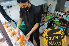 GIGIH KENDALI GERAI: Gitaris Amplified, Muhammad Khairul Ilham, yang juga pencari bakat seni baru buat program harian di Wisma Geylang Serai sebelum ini, kini mengendalikan gerai makanan laut di Redhill Lane dari petang hingga malam. Waktu paginya dihabiskan mengirim makanan ke rumah pelanggan di bawah khidmat GrabFood. - Foto ihsan MUHAMMAD KHAIRUL ILHAM 
