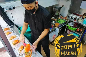 GIGIH KENDALI GERAI: Gitaris Amplified, Muhammad Khairul Ilham, yang juga pencari bakat seni baru buat program harian di Wisma Geylang Serai sebelum ini, kini mengendalikan gerai makanan laut di Redhill Lane dari petang hingga malam. Waktu paginya dihabiskan mengirim makanan ke rumah pelanggan di bawah khidmat GrabFood. - Foto ihsan MUHAMMAD KHAIRUL ILHAM 
