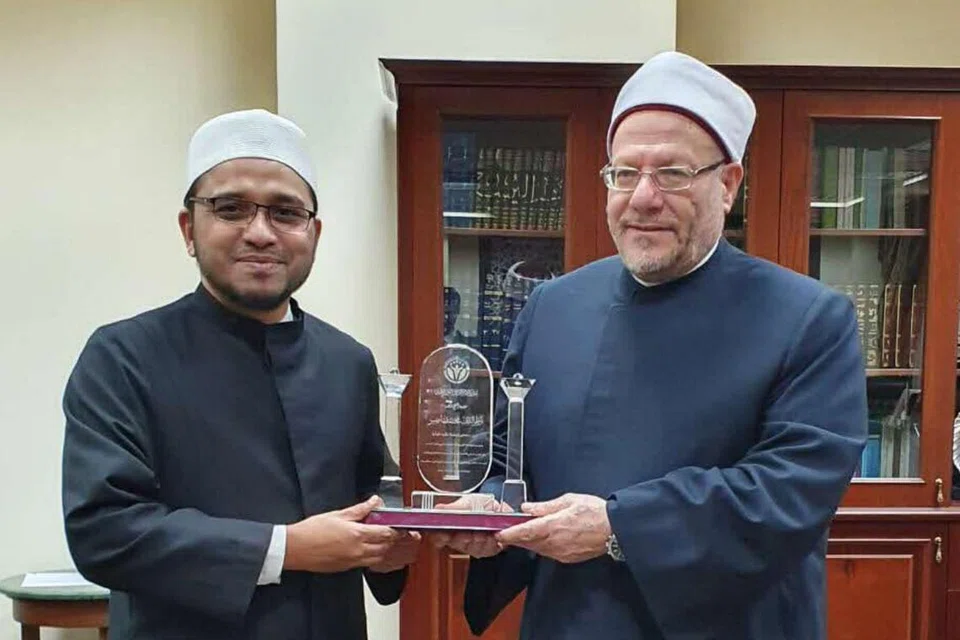 PENGIKTIRAFAN YANG DIHARGAI: Mufti Dr Nazirudin Mohd Nasir (kiri) menerima Anugerah Imam Al-Qarafi bagi Kecemerlangan dalam Fatwa daripada Mufti Besar Mesir, Dr Shawki Ibrahim Allam, di Kahirah pada 2022. Anugerah itu diberikan kepada Jawatankuasa Fatwa Muis yang dipimpin Dr Nazirudin, antaranya kerana menunjukkan pendekatan yang progresif dan cemerlang.