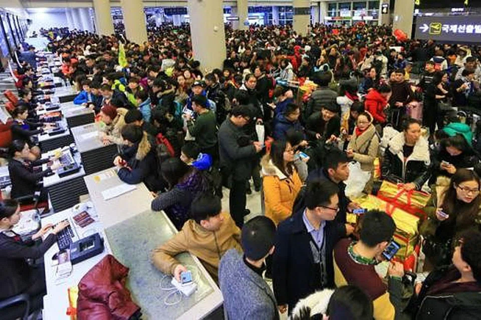 BERASAK-ASAK MAHU BERLEPAS: Foto yang diambil lewat malam kelmarin menunjukkan ribuan penumpang berasak-asak mahu mendapatkan pas masuk di Lapangan Terbang Antarabangsa Jeju. - Foto AFP