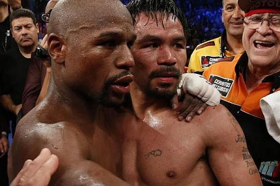 BERDAMAI SELEPAS 'BERMUSUH' DI GELANGGANG: Floyd Mayweather Jr (kiri) dan Manny Pacquiao saling berpelukan di akhir 12 pusingan pertarungan mereka yang berlangsung di MGM Grand Garden Arena, Las Vegas, semalam.