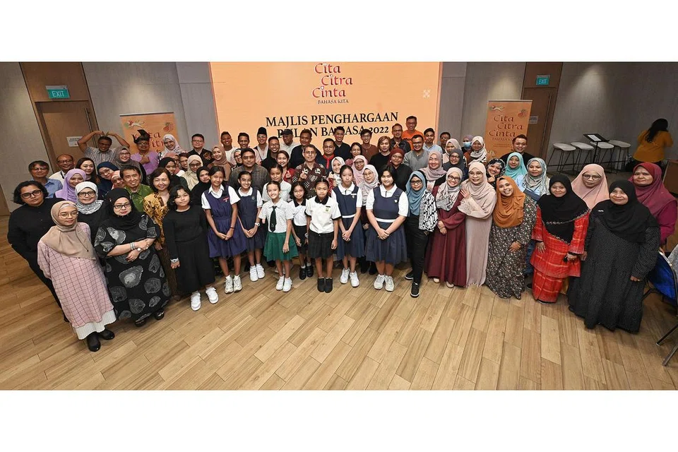 HARGAI KERJASAMA: Dr Faishal dan Cik Rahayu bergambar bersama lebih 70 tetamu di majlis penghargaan Bulan Bahasa 2022 semalam. - Foto BH oleh KHALID BABA