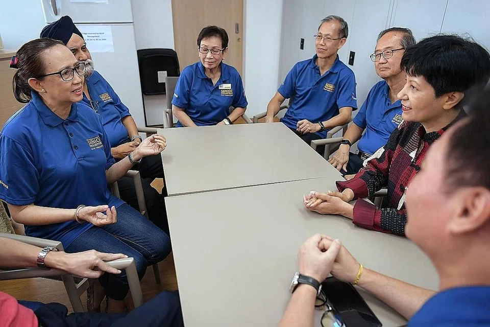 SUKARELAWAN EMAS: Cik Indranee (berbaju merah) sempat meluangkan masa mendengar pengalaman dan bertukar-tukar pandangan dengan sekumpulan sukarelawan RSVP Singapore termasuk Cik Khartini Longpoetih (paling kiri) dalam lawatannya semalam. - Foto BH oleh SOR LUAN