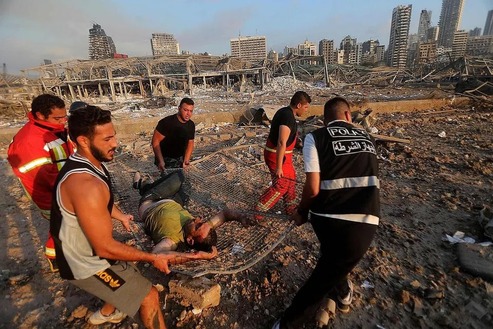 SELAMATKAN MANGSA: Mangsa letupan dibawa anggota tentera Lebanon dan penduduk awam untuk mendapatkan rawatan di hospital di Beirut. - Foto-foto AFP