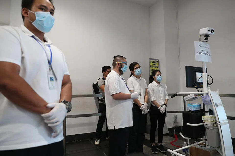 LANGKAH PENCEGAHAN: Kakitangan perubatan menunggu penumpang turun di Pusat Pelayaran Singapura untuk menjalankan ujian swab hidung jika perlu. - Foto BH oleh TIMOTHY DAVID