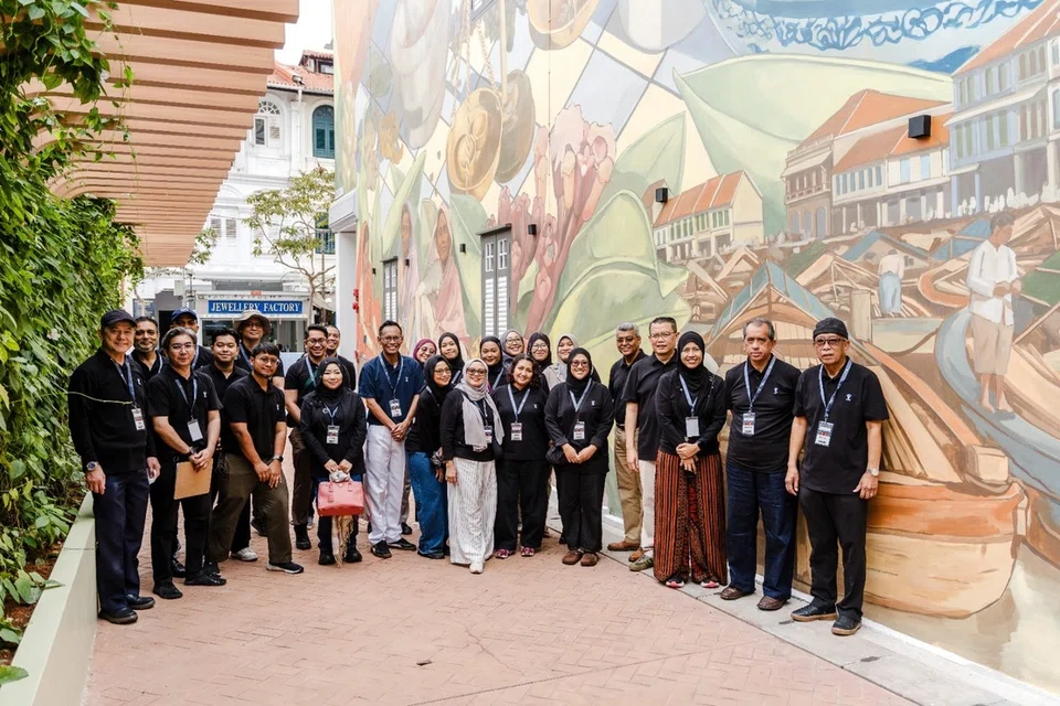 Wakil daripada Warees Investments bergambar di hadapan lukisan mural warisan sepanjang laluan pejalan kaki ‘The Thoroughfare’.